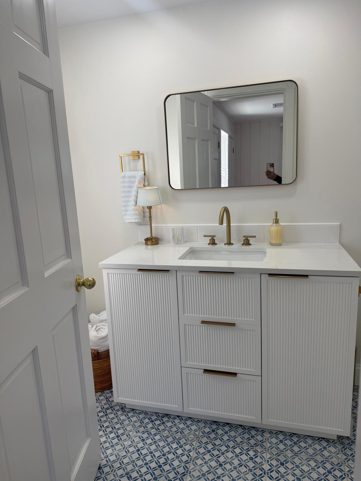 Bathroom vanity with gold faucet and mirror polished
