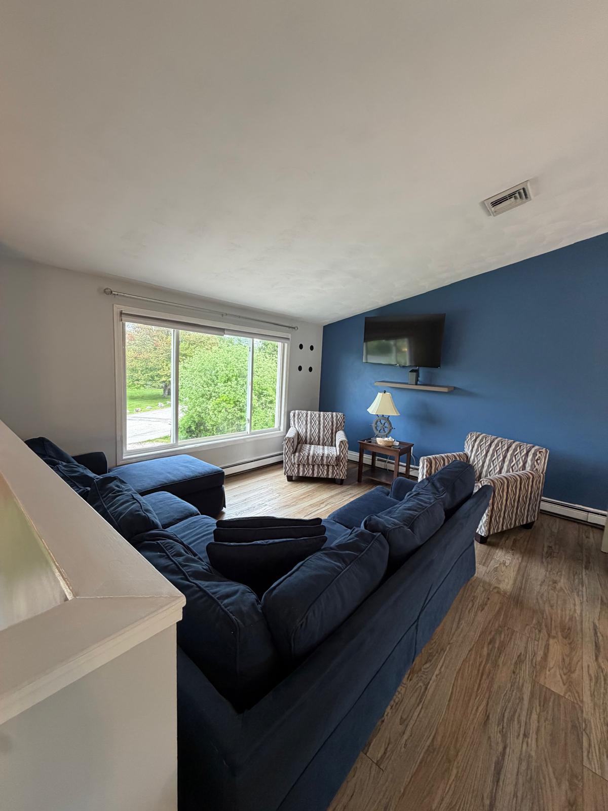 Living room with blue sectional sofa cleaned and organized