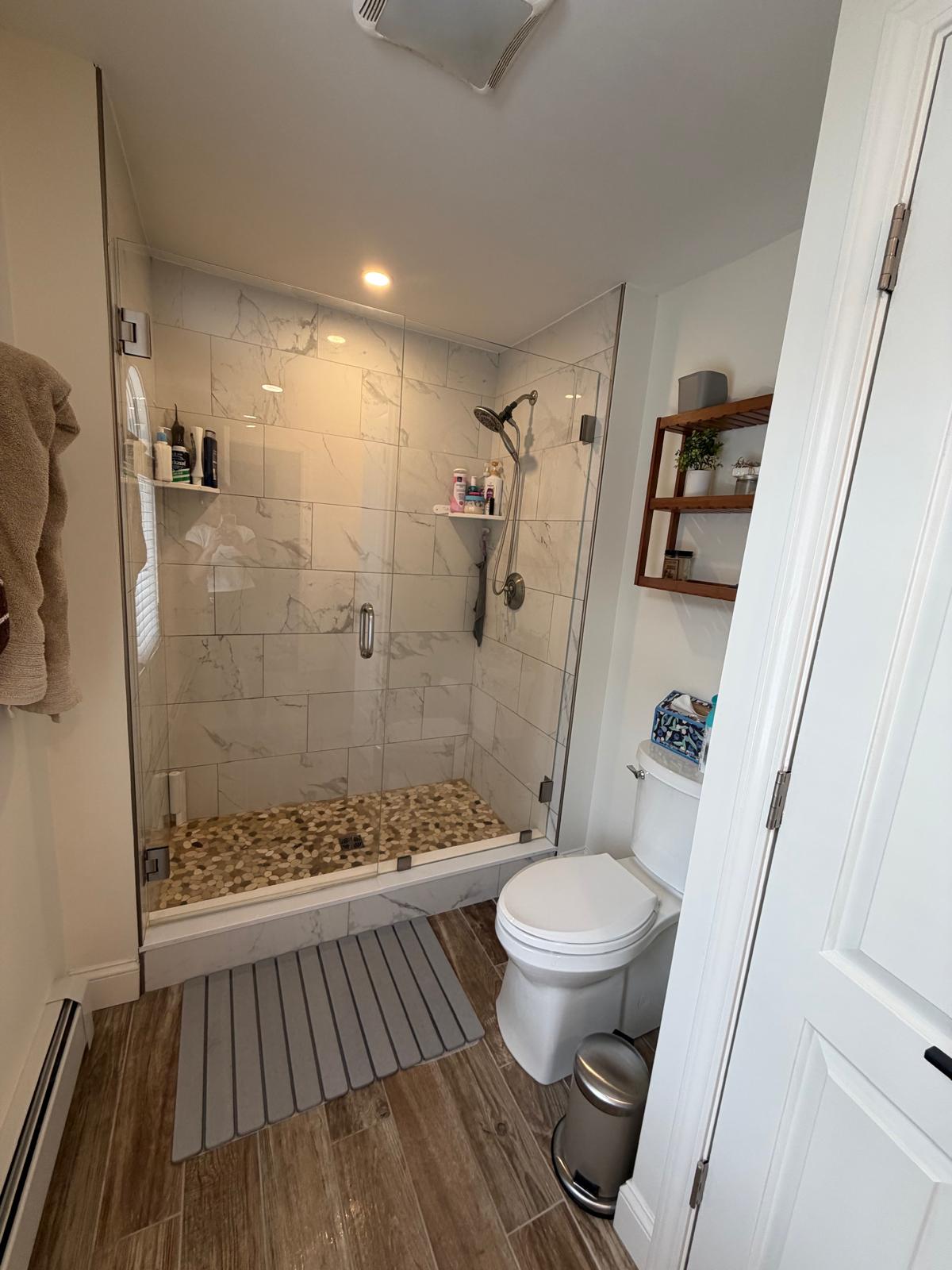 Marble-look tile shower with glass door cleaned and streak-free