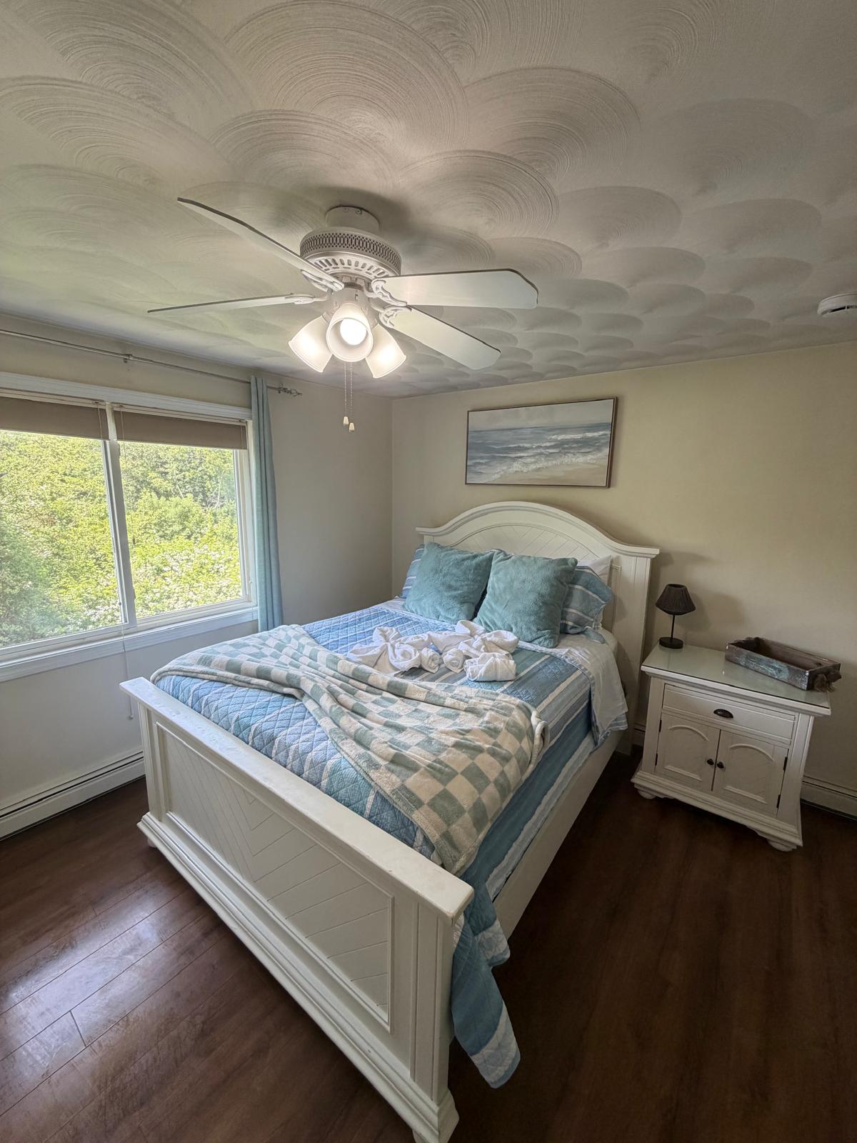 Bedroom with fresh linens and decorative towel folds after cleaning