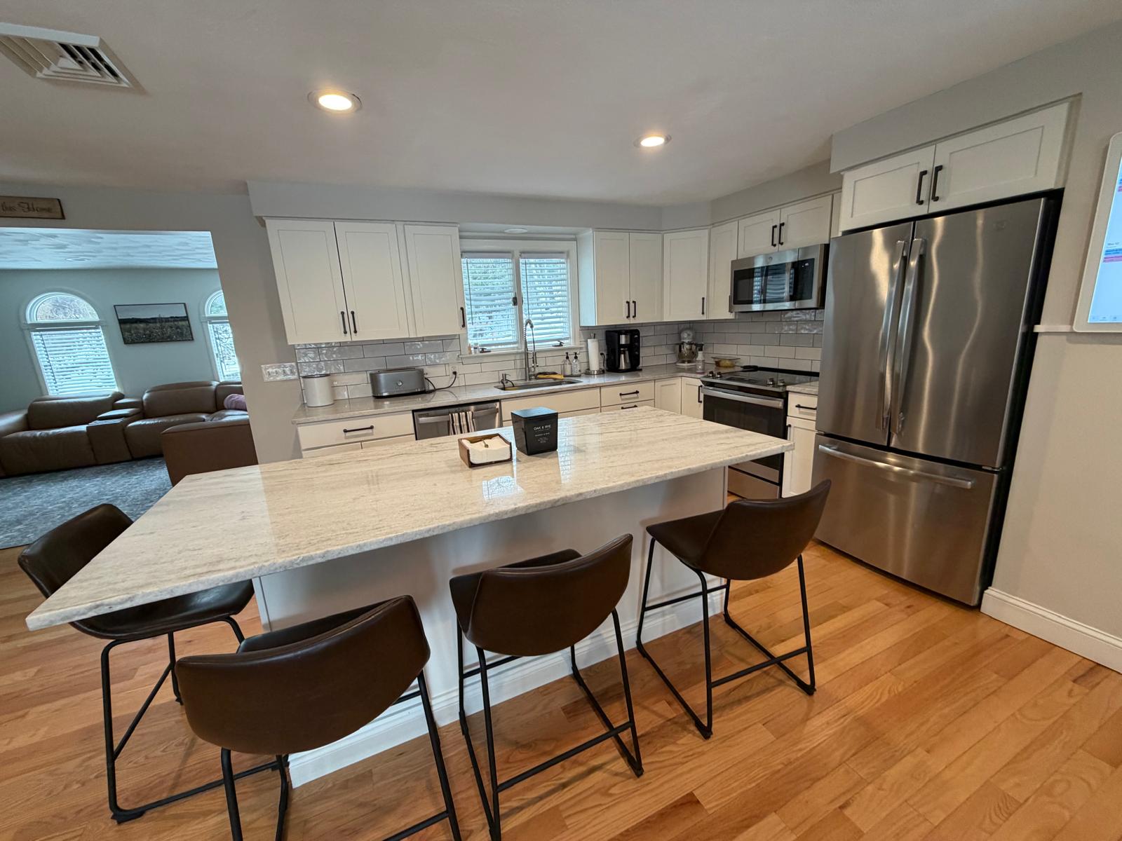Open kitchen with marble island and stainless steel appliances sparkling clean
