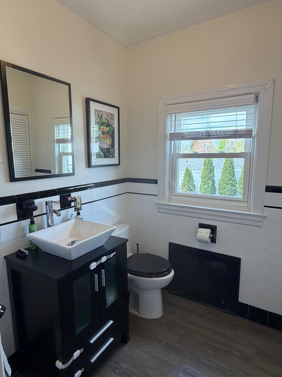 Bathroom with black vanity and vessel sink detailed and shining