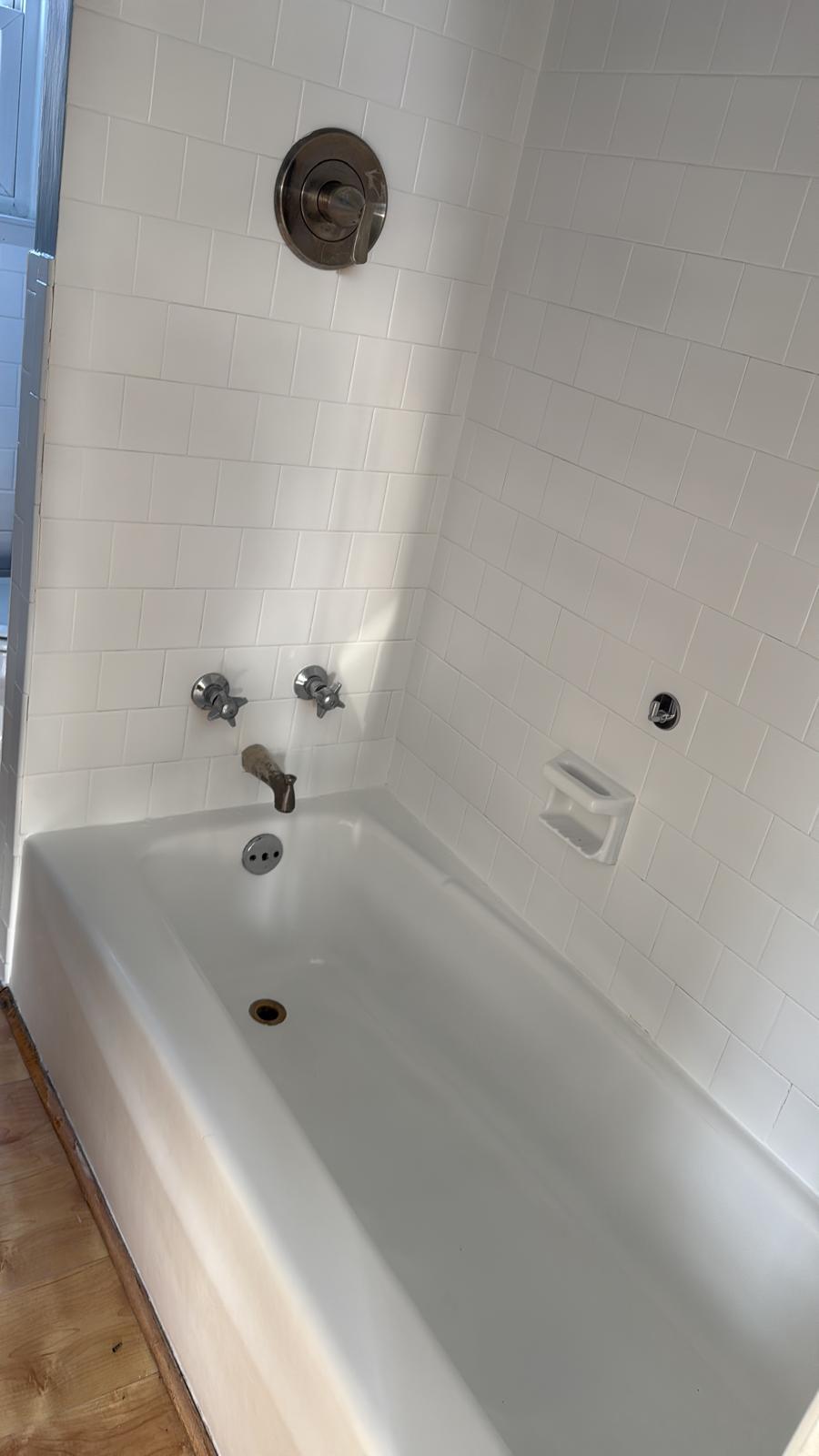 White bathtub and subway tile scrubbed and shining