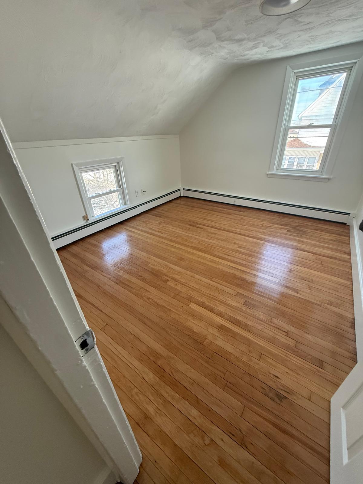 Bedroom with gleaming hardwood floors after a move-out cleaning